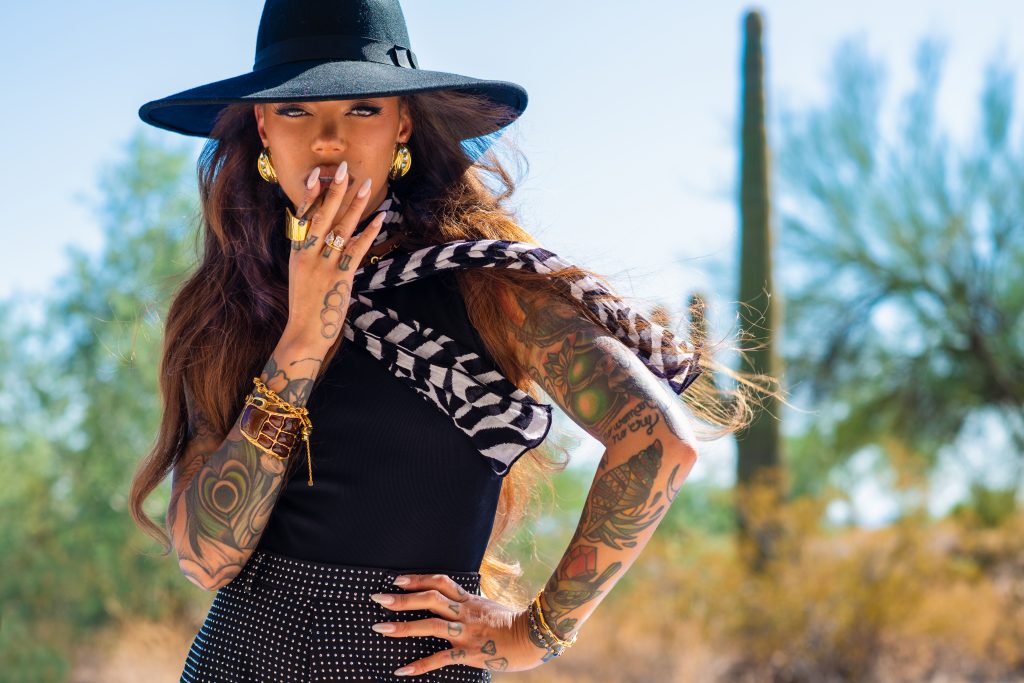 Beautiful tattooed female model Miryam Lumpini enjoying an Al Capone Sweets Filtered Cigarillo during high-energy photoshoot