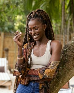 Woman relaxing with a sweet cigarillo in hand on a sunny patio
