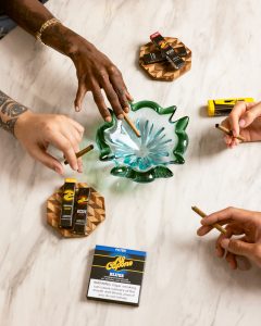 Stylish swag bags filled with beverages, chocolates, skincare, and Al Capone cigarillos on a modern table