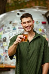 Cozy cabin scene with luggage, blankets, snacks, firewood, and Al Capone cigarillos on a rustic table