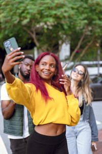 Scenic weekend getaway with packed bags, cozy cabin view, wine glasses, and Al Capone cigarillos placed for adult relaxation